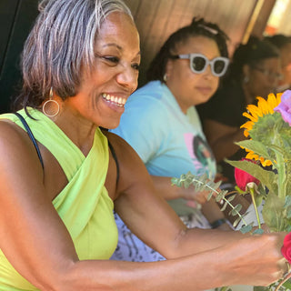 Black senior woman designing a flower bouquet