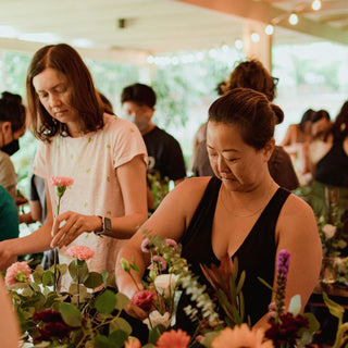 Two woman arranging flowers.