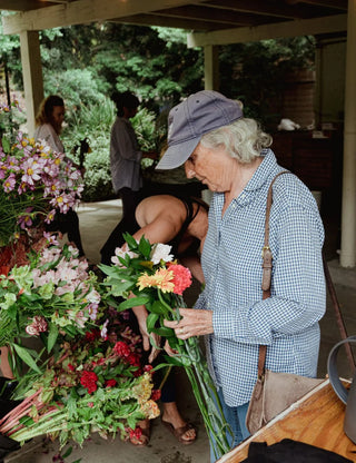 Senior woman with a cap selecting flowers